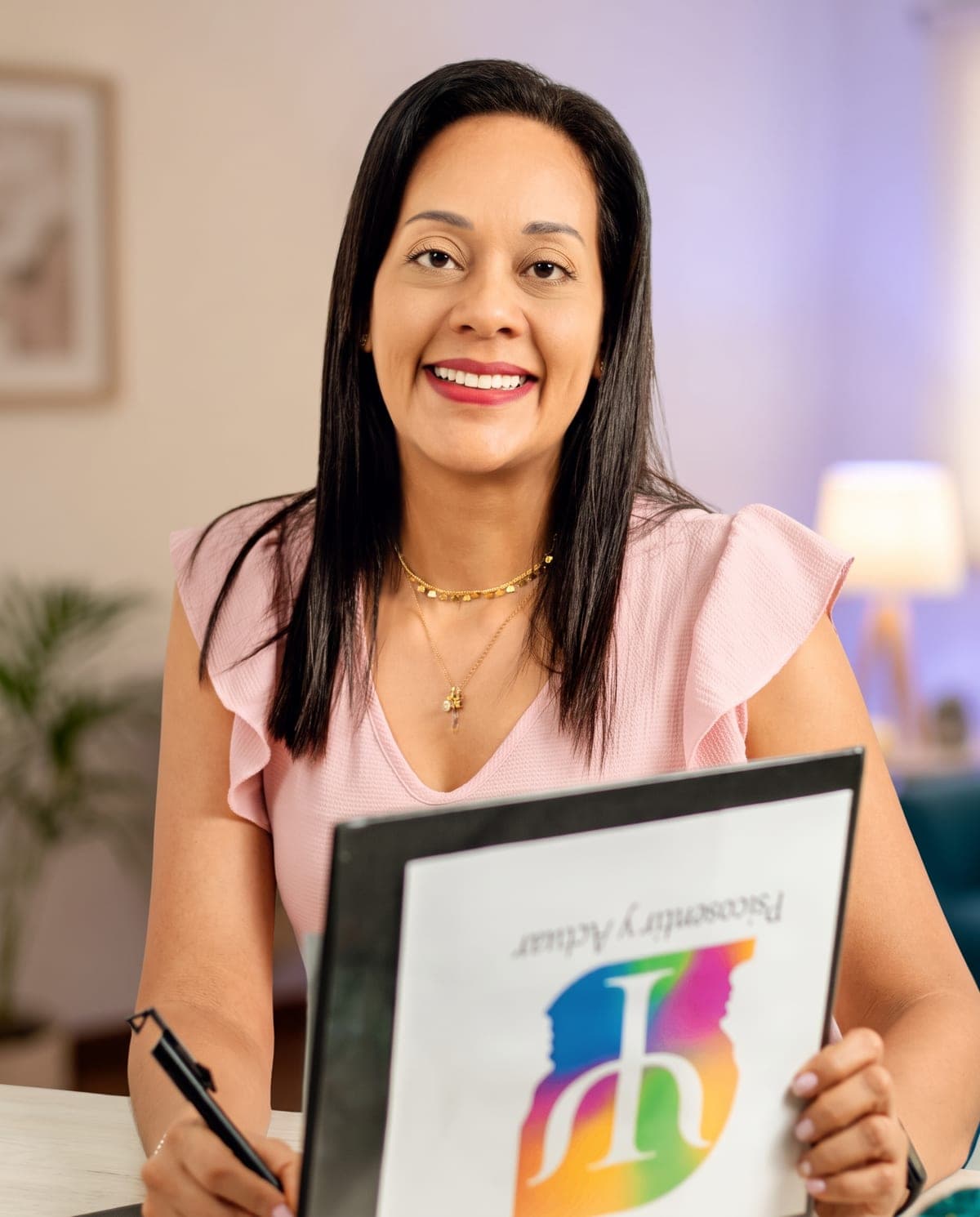 Adriana Gómez Peña en su consultorio en Cali, sosteniendo la carpeta de Psicosentir y Actuar